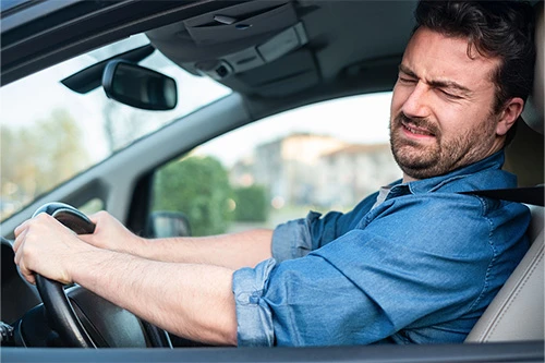 Stop for Brake Repair When You Spot These 4 Signs | Kanuga Tire & Auto in Hendersonville, NC. Image of a man driving his car hearing strange sounds while braking.