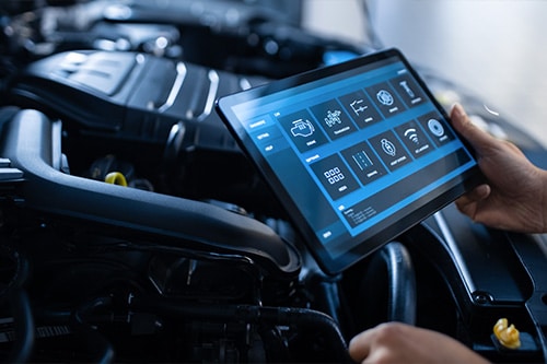 Auto mechanic uses a tablet to diagnose and record inspection results. Concept image of “Digital Vehicle Inspection: 4 Things You Need to Know” | Kanuga Tire & Auto in Hendersonville, NC.