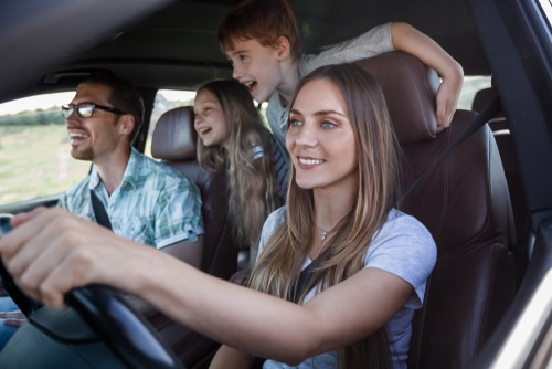 Spring Car Maintenance service near me in Hendersonville, NC with Kanuga Tire and Auto. Image of a happy family inside a car, with the parents having peace of mind knowing the car is ready for spring.